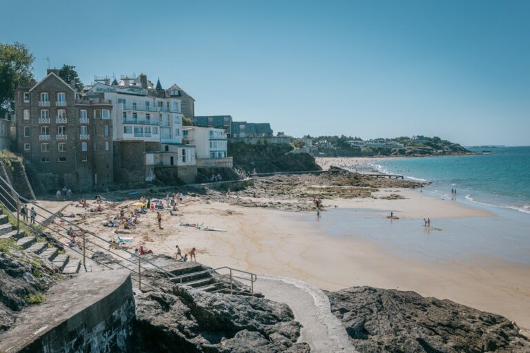 A sandy beach with people walking on it